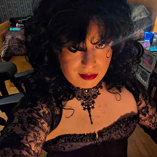 Mistress is looking at the camera lit from below.