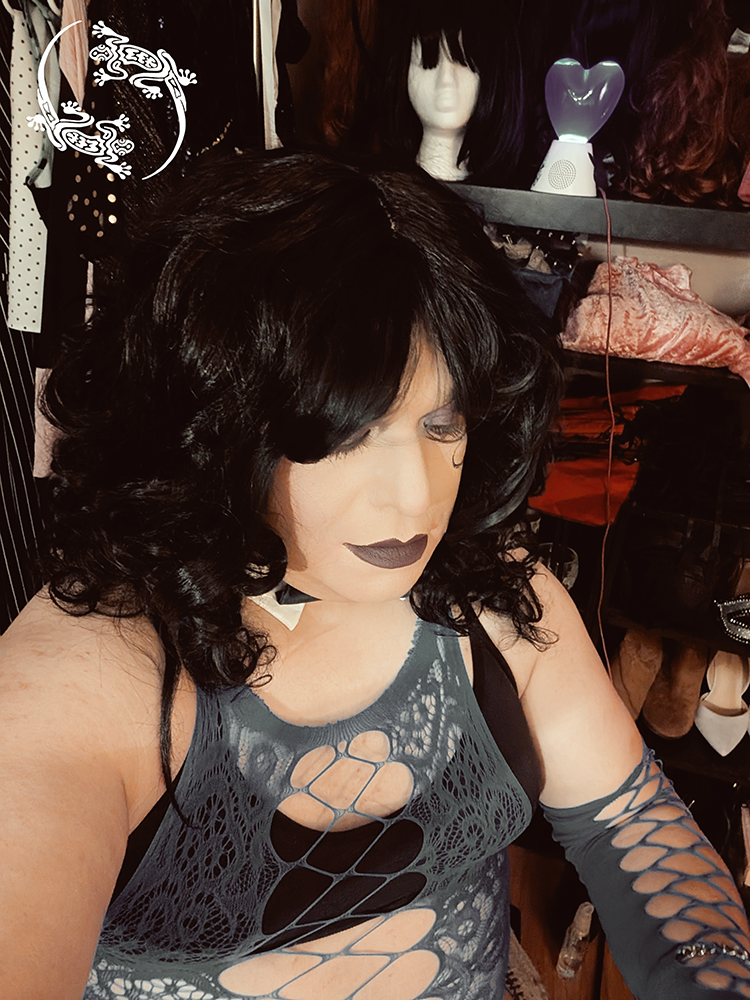 Mistress Ilya is looking away from the camera. 