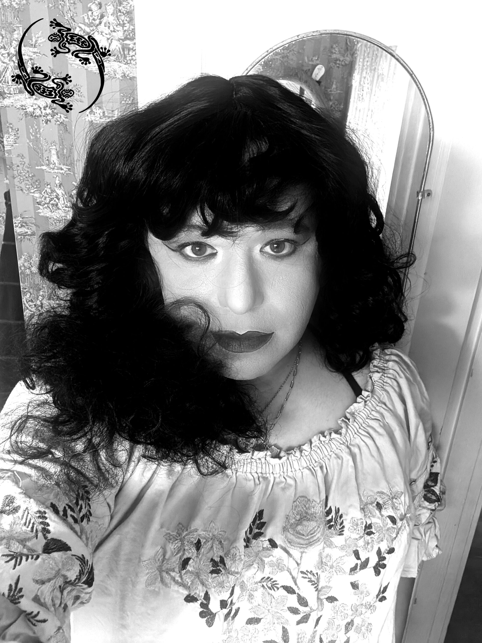 Mistress Ilya took a selfie in her bathroom. There is a mirror behind her.