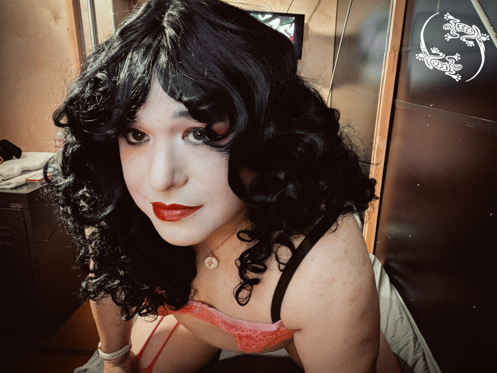 Mistress Ilya is looking into the camera with her head tilted. 