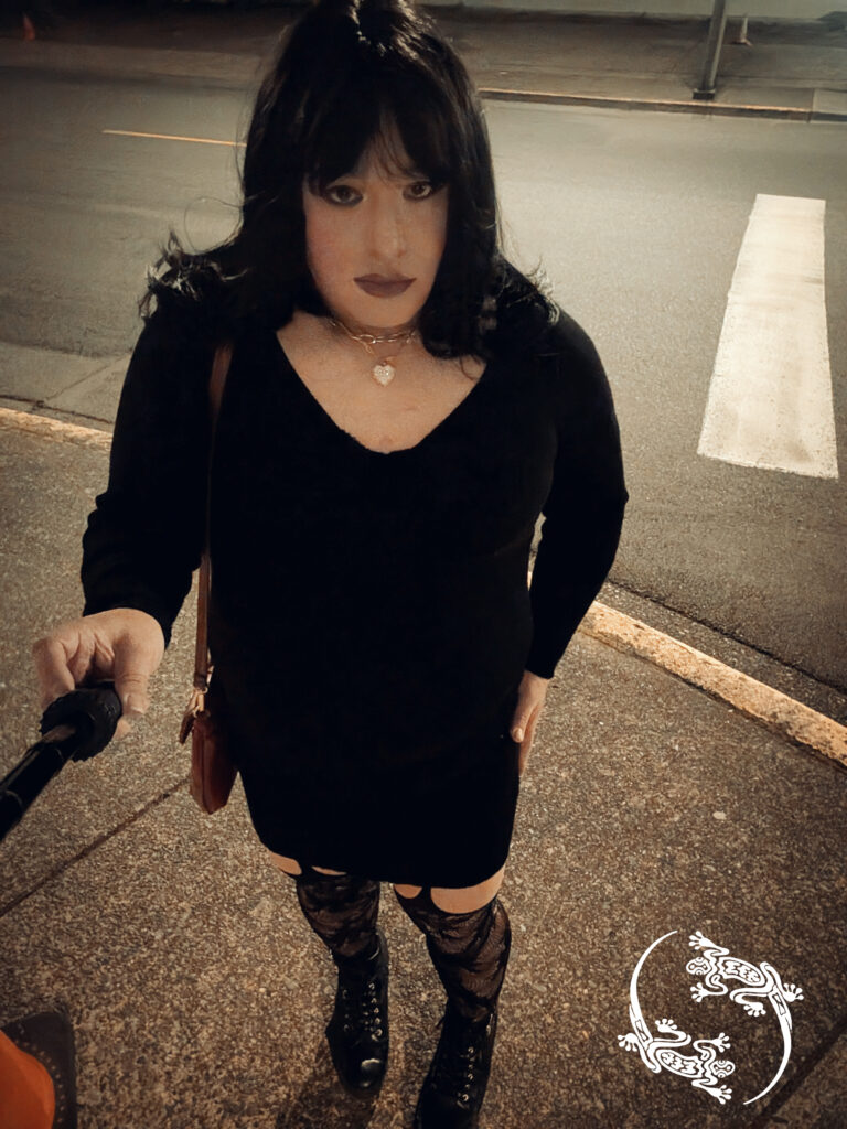 Mistress Ilya is on the street at night taking a selfie.