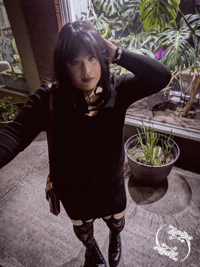 Mistress Ilya is outside a plant store at night.