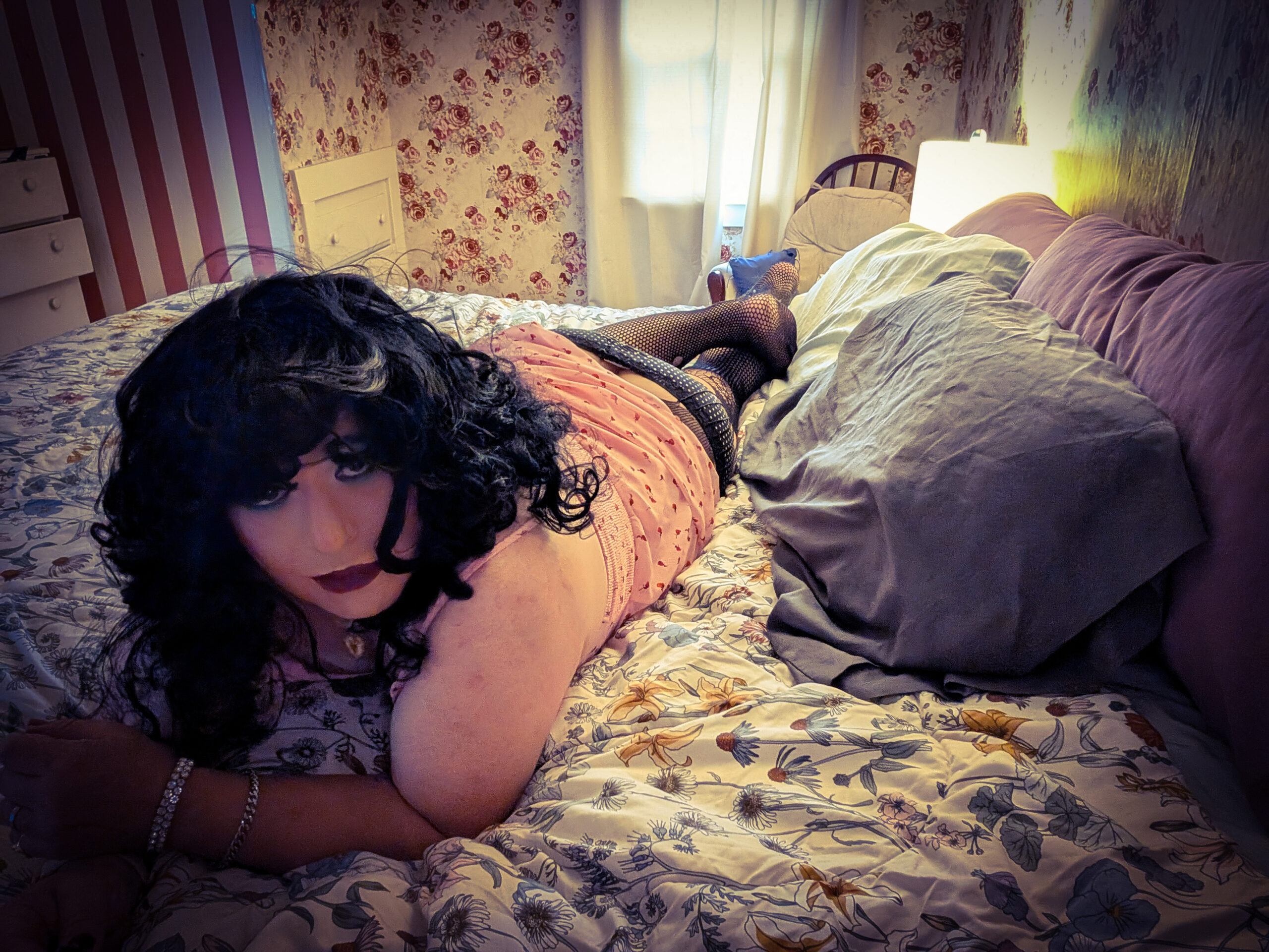 Mistress Ilya is laying on her bed facing the camera. 