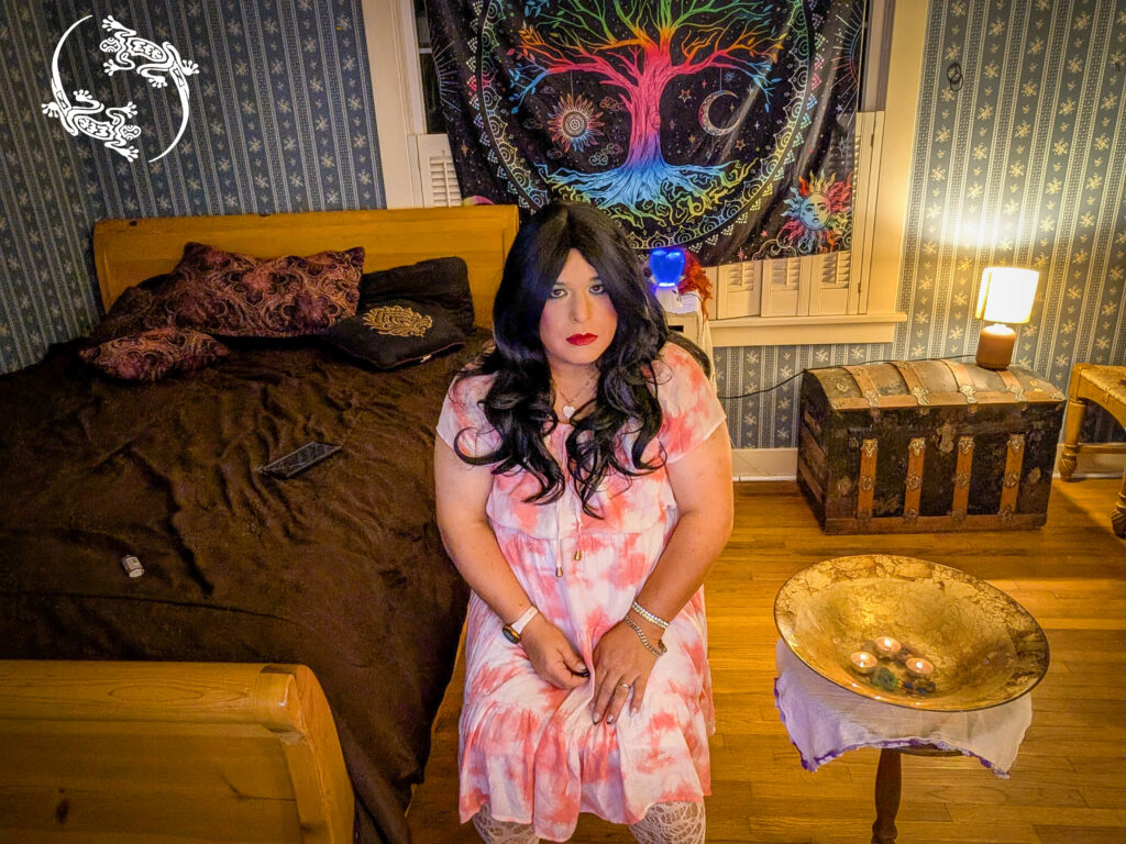 Mistress Ilya is sitting on her chair in her room by her altar. 