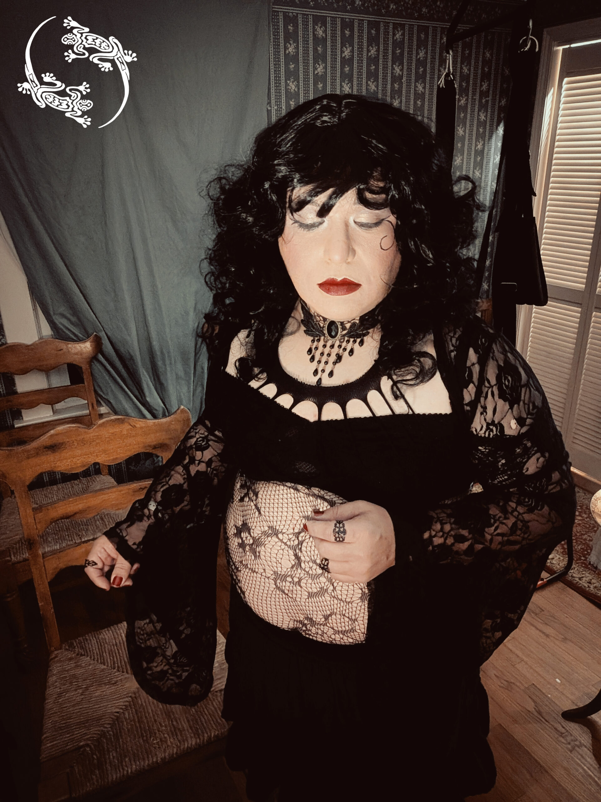 Mistress Ilya has her eyes closed while taking a selfie.