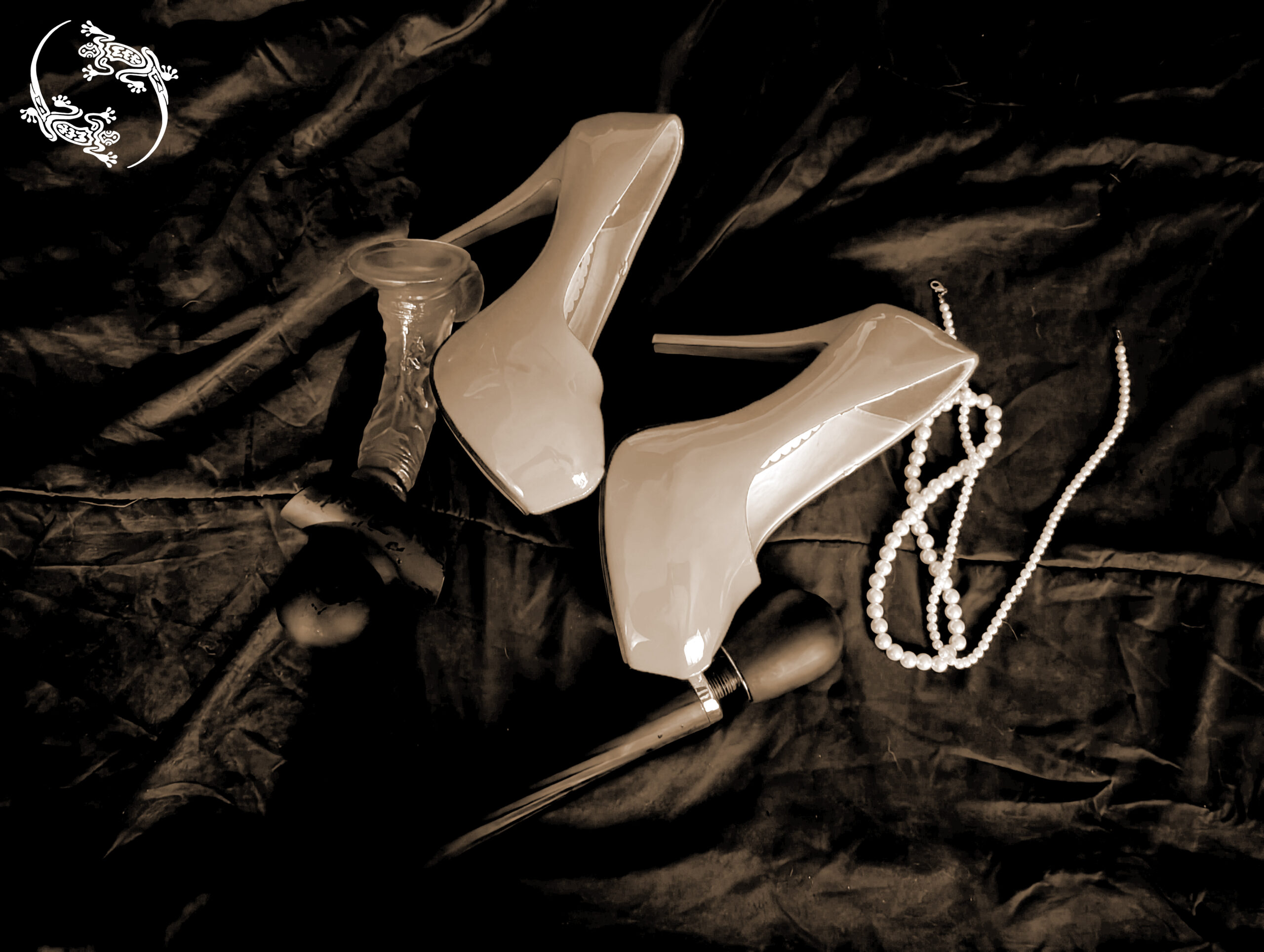 A pair of shoes, necklace, and adult toys on a bed.