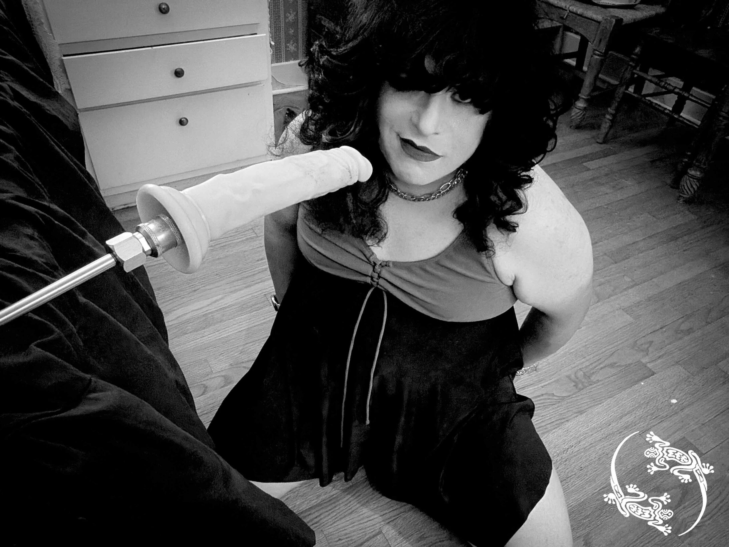 Mistress Ilya is on her knees before a dildo on a fuck machine. 