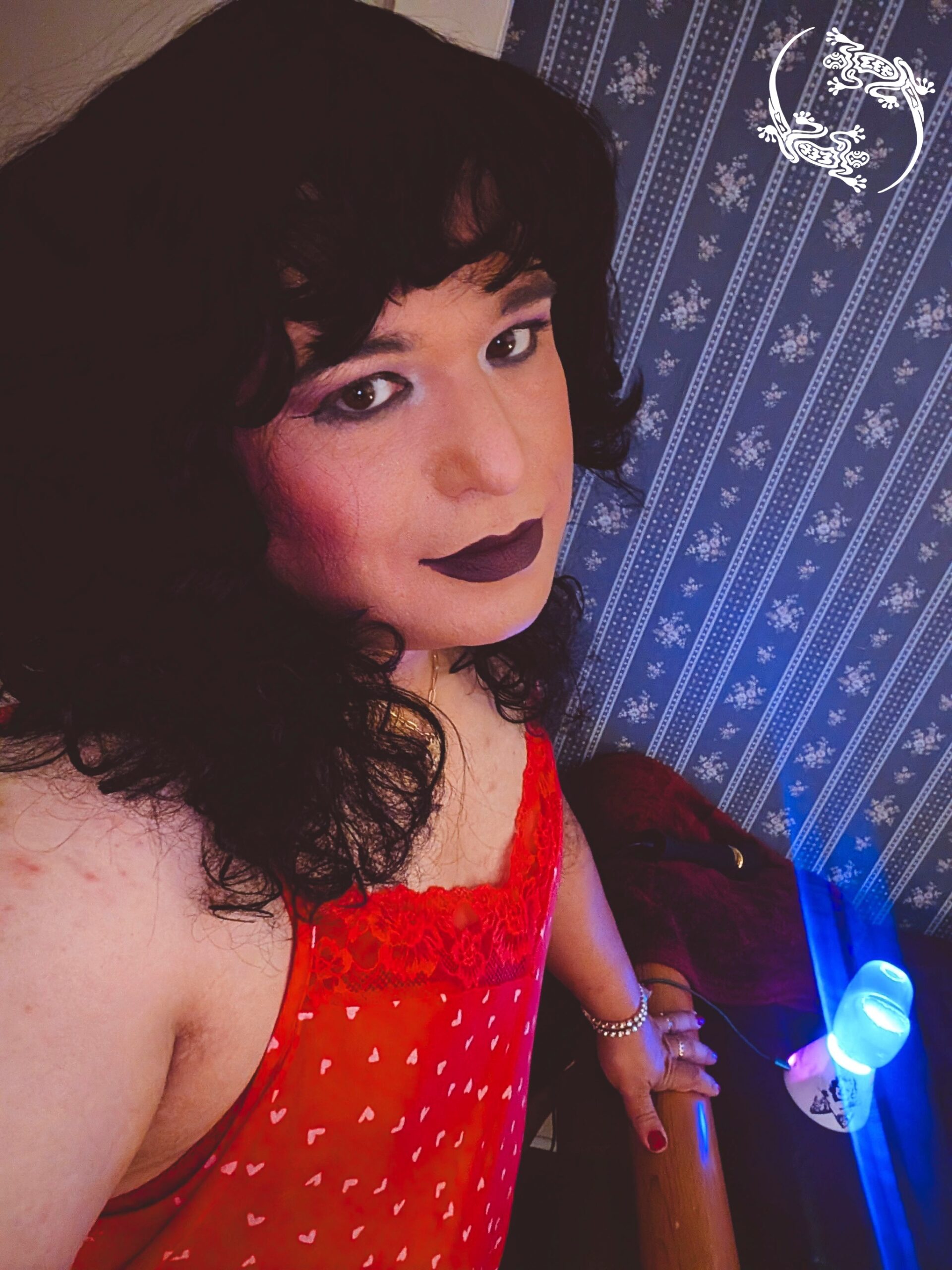 Mistress Ilya is looking to the side at the camera.