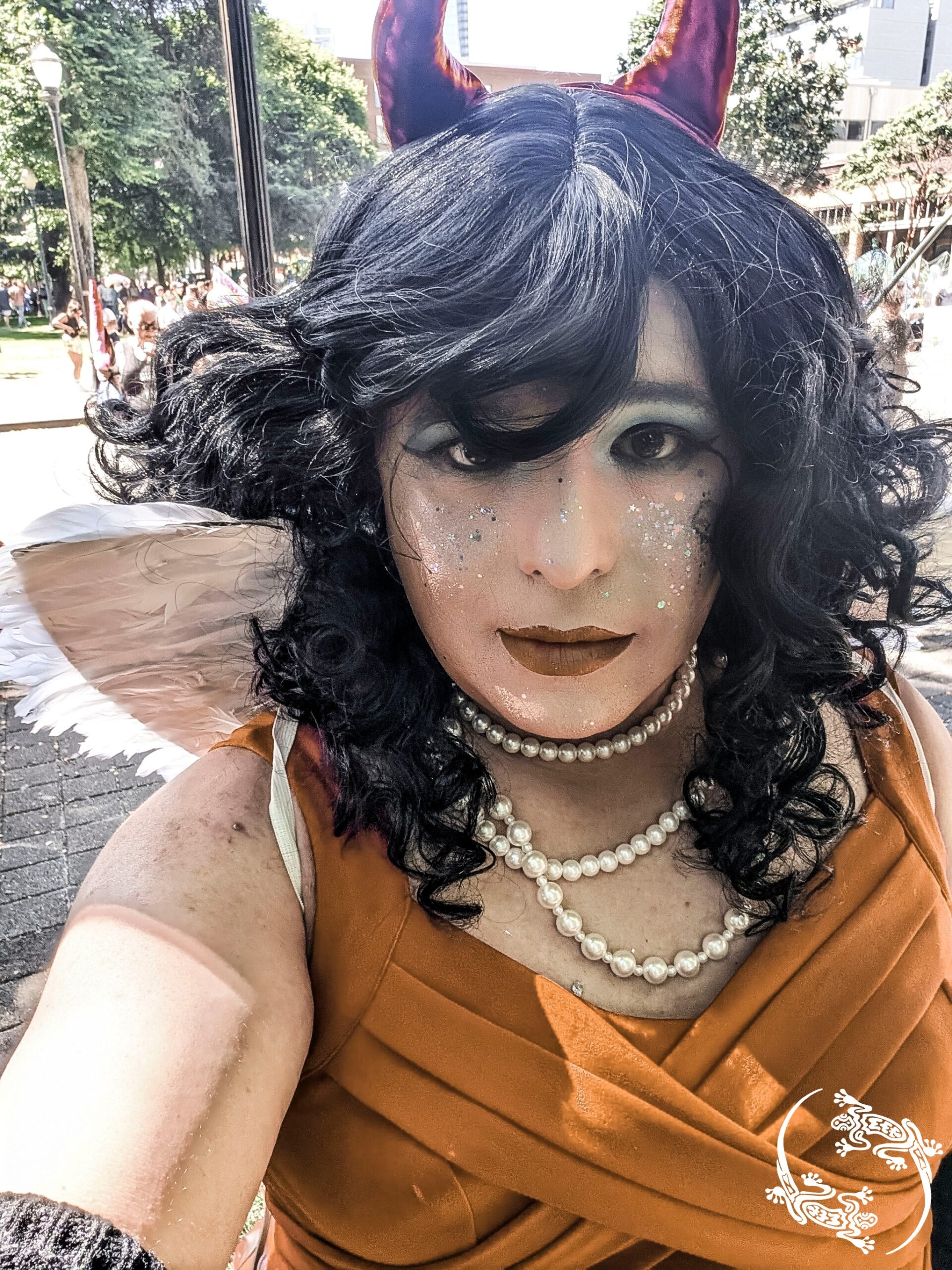 Mistress Ilya is wearing angel wings and a long dress while taking a selfie at downtown Portland.